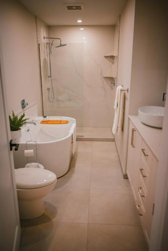 a bathroom with a tub and a toilet and a sink at Courtenay Luxe Suite in Courtenay
