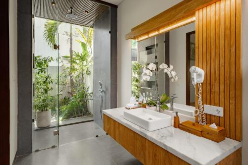 a bathroom with a sink and a large window at Elitya Ubud Villa in Ubud