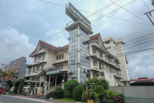 a building with a street sign on top of it at Hotel Surya Asia in Ngasinan