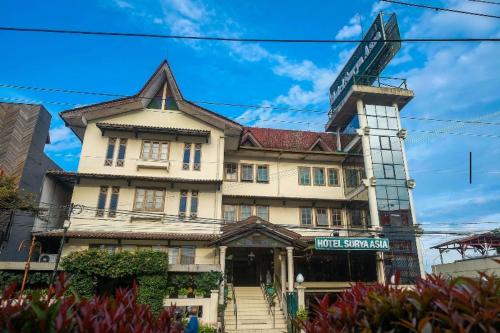 a large building with a sign in front of it at Hotel Surya Asia in Ngasinan