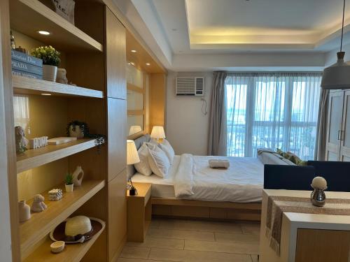 um pequeno quarto com uma cama e uma janela em Amazing Sunrise Venice Grand Canal Balcony, Xbox Series X console with Game Pass Ultimate, FREE coffee, Pool, Gym & Sauna, 5 mins to BGC em Manilla