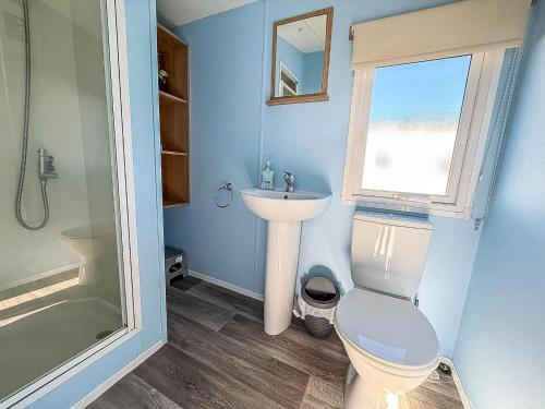 a bathroom with a toilet and a sink and a window at Lovely 8 Berth Caravan At Manor Park Nearby Hunstanton Beach 23107S in Hunstanton