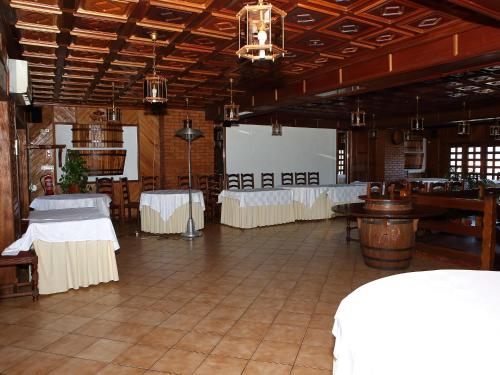 un salón de banquetes con mesas blancas y una pantalla de proyección en Residencial Albergaria, en Paredes de Coura