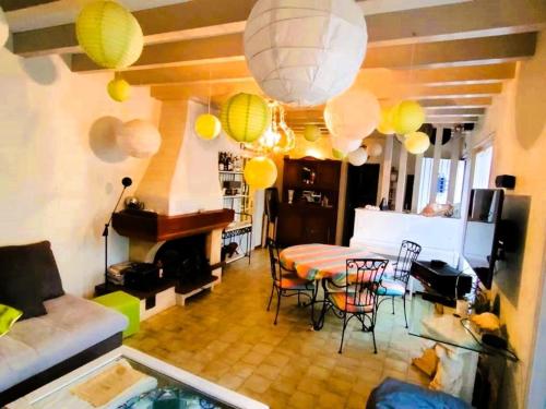 - un salon avec une table, des chaises et des lumières dans l'établissement Grande maison à Capbreton avec véranda et jardin pour 10 personnes - FR-1-239-1102, à Capbreton