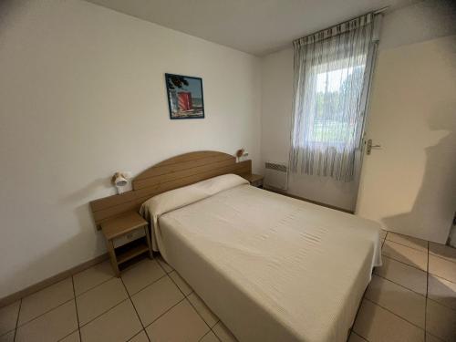 une petite chambre avec un lit et une fenêtre dans l'établissement Appartement T3 Familial à Ondres avec Piscine et Parking - FR-1-239-1103, à Ondres