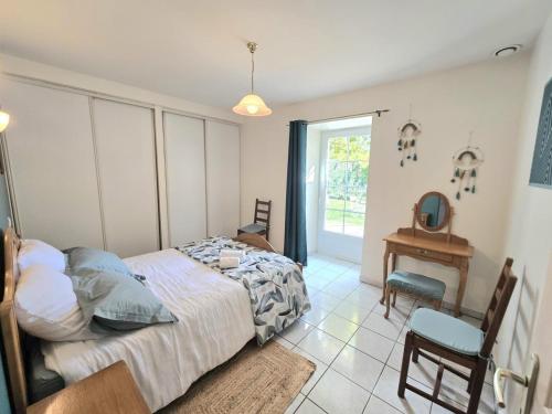 Un dormitorio con una cama y una mesa y una ventana. en Gîte de charme avec cheminée en Dordogne - FR-1-616-466, en Tourtoirac