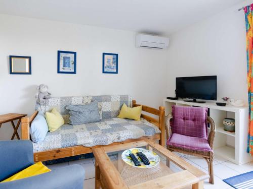 un salon avec un canapé et une télévision dans l'établissement Villa 3 pièces avec grand jardin, piscine collective, vue mer - FR-1-409-277, à Fleury