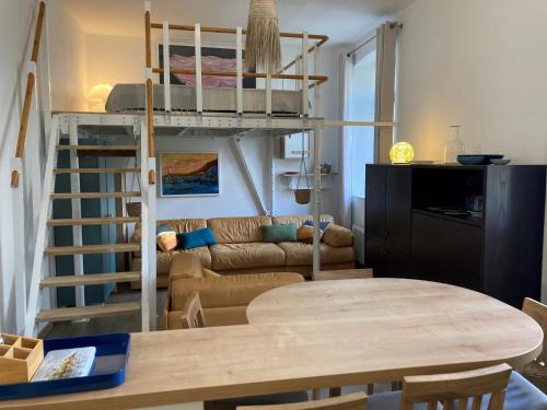 - un salon avec des lits superposés et une table dans l'établissement Studio neuf avec mezzanine au cœur de Le Palais, proche plages - FR-1-418-267, au Palais