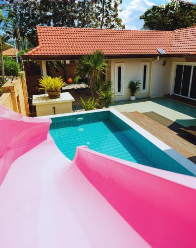 a swimming pool in front of a house at Princess Massarossa Pool Villa Pattaya-24 in Pattaya
