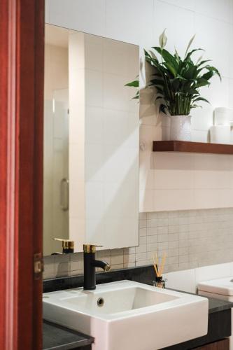 a bathroom sink with a mirror and a potted plant at Princess Massarossa Pool Villa Pattaya-24 in Pattaya