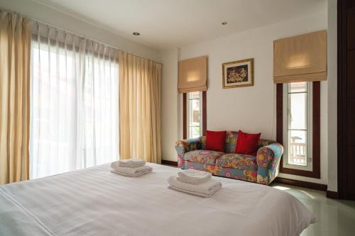 a bedroom with a large bed and a couch at Princess Massarossa Pool Villa Pattaya-24 in Pattaya