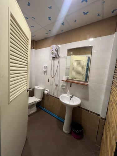a bathroom with a sink and a toilet and a mirror at Lemonade Boutique Inn in Ko Lanta
