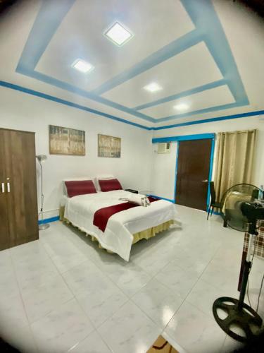a bedroom with a large bed in a room with blue ceilings at Lens Staycation 1-BDR-BR-KTCHN in PANABO in Panabo