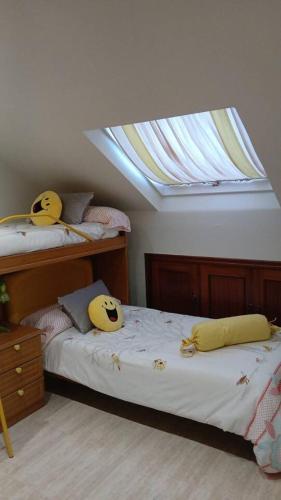 a bedroom with two twin beds with a skylight at Area da Barca Atico in Samieira