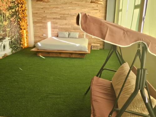 a bedroom with a bed and green carpet at Camping con jacuzzi en la ciudad in San Baltasar