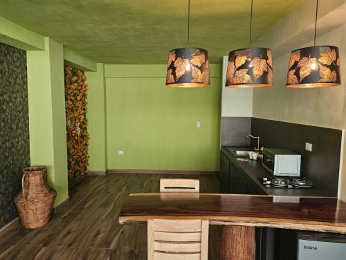 a kitchen with green walls and two lights and a table at Camping con jacuzzi en la ciudad in San Baltasar