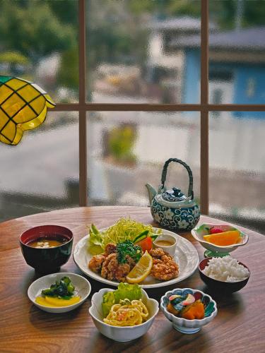 a table with plates of food and bowls of food at Rong Hua Grand Hotel ロンカグランドホテル in Isahaya