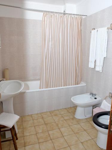 a bathroom with a tub and a sink and a toilet at Residencial Albergaria in Paredes de Coura