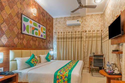 a bedroom with a bed and a flat screen tv at Treebo Una Regency - Near AIIMS Patna in Patna