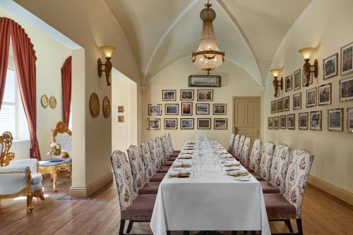 a long dining room with a long table and chairs at Palace Gate Hotel & Resort By EHM in Phnom Penh