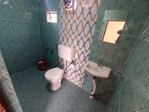a bathroom with a toilet and a sink at Lawanba Home Stay in Dum-Dum Junction