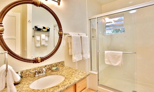 a bathroom with a shower and a sink and a mirror at Beso Del Sol in Huntington Beach