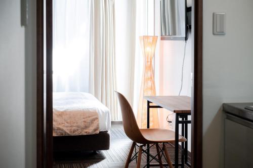 a bedroom with a bed and a table and chairs at Base in Kyoto Hanazono in Kyoto