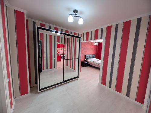Stylish apartment في كيشيناو: غرفة ذات جدران مخططة باللونين الأحمر والأبيض ومرآة