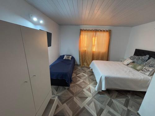 a small room with two beds and a window at Hospedaje en Monte Grande in Monte Grande