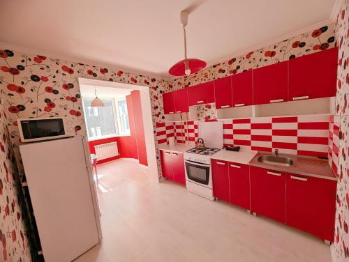 Stylish apartment في كيشيناو: مطبخ مع دواليب حمراء وثلاجة بيضاء