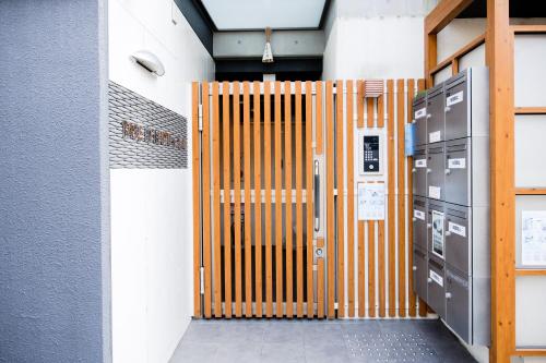 a wooden door in a room with two machines at Base in Kyoto Hanazono in Kyoto