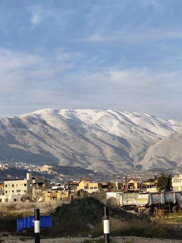 a snow covered mountain in the background of a city at סוויטת לורד הרמיטאז' בגלון in Bruchim