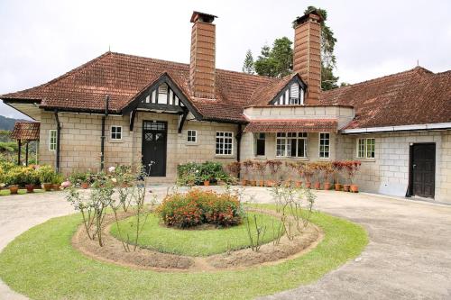 a large house with a garden in front of it at Bukit Lowick Bungalow in Tanah Rata