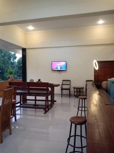 a living room with a flat screen tv on a wall at Ubud Suites Batuan in Sukawati