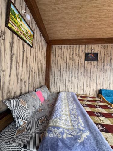a bedroom with a bed in a room with wooden walls at Cafekush tosh in Tosh
