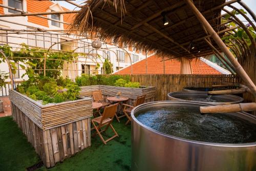 an outdoor patio with a hot tub and tables and plants at Palace Gate Hotel & Resort By EHM in Phnom Penh