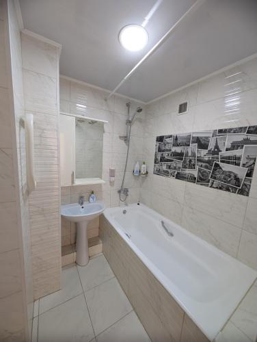biała łazienka z wanną i umywalką w obiekcie Nice apartment w Kiszyniowie