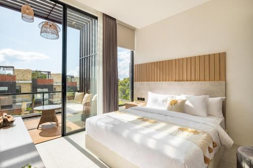 ein Schlafzimmer mit großem Bett und Balkon in der Unterkunft Private Villa Ayra 9C By OriVista 10min to Melasti Beach in Uluwatu