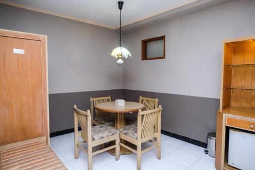 a dining room with a wooden table and chairs at Hotel Surya Asia in Ngasinan