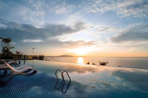 a swimming pool with a view of the ocean at Mandala Oceanfront Driftwood Resort in Phan Thiet