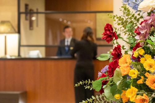 a man and a woman standing at a counter at Hotel Nikko Oita Oasis Tower in Oita