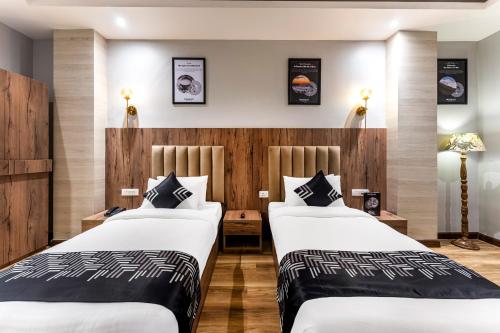 two beds in a hotel room with wooden walls at Medalio Boutique Gangtok with Mountain View in Gangtok