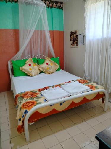 a bed with pillows and towels on it in a room at Villa 301 B&B in Baclayon