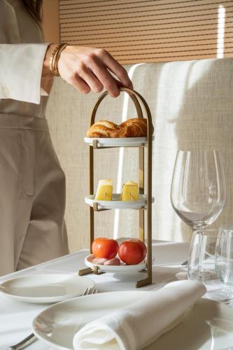 a person reaching for a plate of food on a table at Les Clarisses Boutique Hotel in Vic