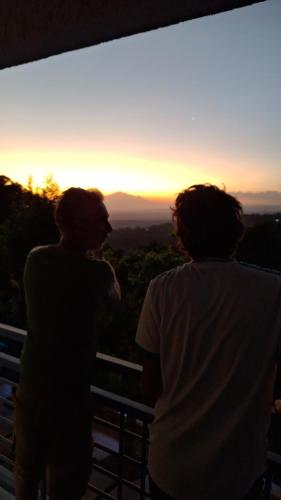 two people standing on top of a hill looking at the sunset at Materuni Homes in Moshi