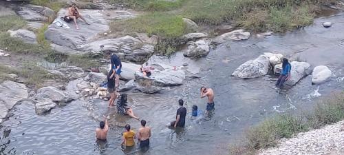 a group of people in the water in a river at Nisarg Camping Pods in Almora