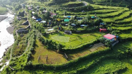 a small village on a hill near the ocean at Nisarg Camping Pods in Almora