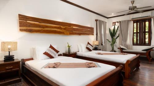 a bedroom with two beds and a living room at Khmer Lodge - Eco-Lodge in Phumĭ Réach Born