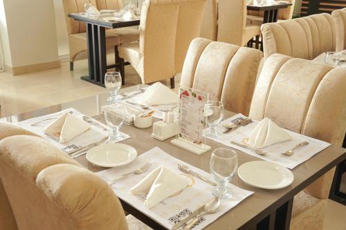 a table with plates and wine glasses on it at Falettis Express Islamabad in Islamabad