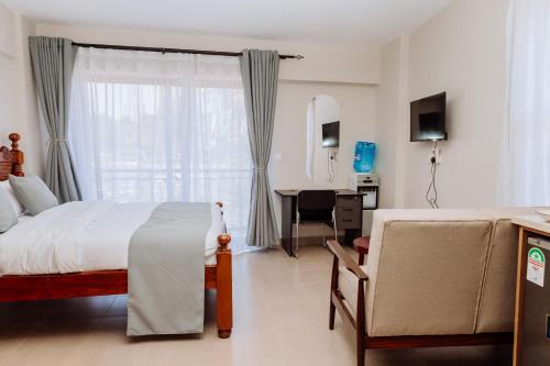 a bedroom with a bed and a desk and a window at Miiza Realtors in Nairobi